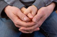 Ein Junge und  ein Erwachsener halten ihre betende Hände ineinander.